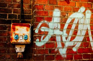 Backsteinwand mit Graffiti & rostigem Schaltschrank – urbane Industrial‑Wandkunst