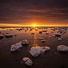 De Waddenzee is bedekt met IJsschotsen in de winter. Een mooie zonsondergang geeft prachtige kleuren van Bas Meelker