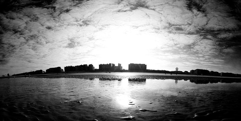 Sunlit Beach View with Reflections and Silhouettes of Skyscrapers in Black and White by Youri Mahieu