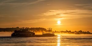 Panorama: Un navire sur la rivière Waal avec le soleil levant.