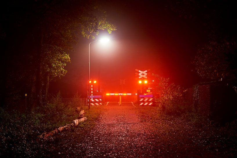 Night photo closed level crossing by Jenco van Zalk