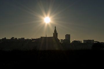 Silhouet van de Stevenskerk in Nijmegen met een prachtige zon met zonnestralen van Patrick Verhoef