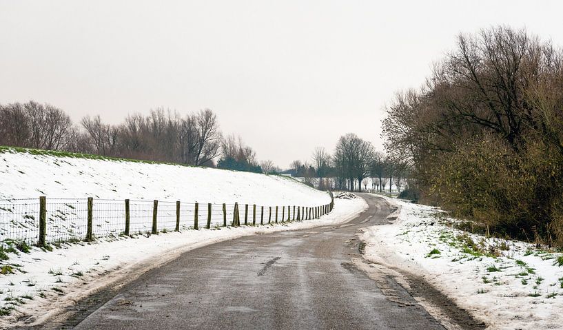 Landweg in een sneeuwlandschap van Ruud Morijn