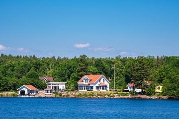 Ostseeküste mit Bäumen und Häusern nahe der Insel Uvö