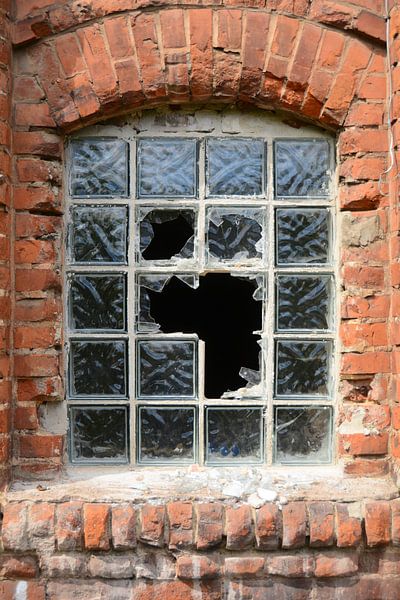 zerstörtes Fenster an der Fassade einer stillgelegten Fabrik von Heiko Kueverling