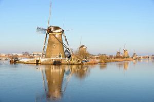 Molens in Kinderdijk met ijs op het water