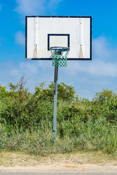 Lonely basketball hoop in a dune landscape by Alexander Baumann