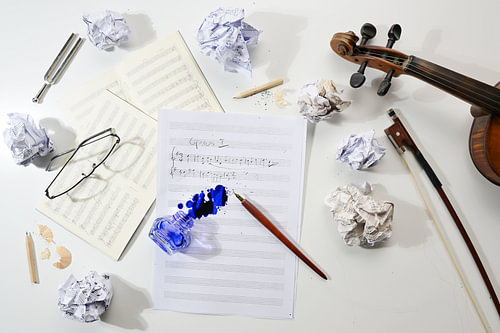 Arbeitsplatz eines Musikers, zerknülltes und flaches Notenblatt, handschriftliche Notation einer Mus