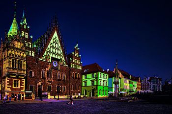 Vue d'une place avec des bâtiments aux couleurs vives la nuit