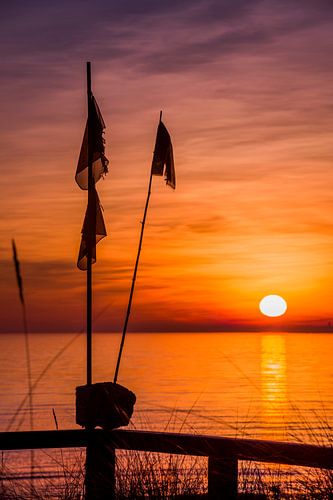 Vissersboei op het strand van de Oostzee bij zonsopgang.