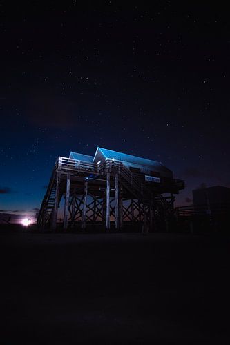 Paalwoningen in het wad 's nachts