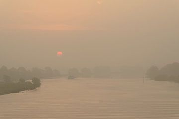 Schip in een zonsopgang over de IJssel tijdens een mooie herfstochtend