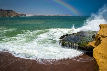 Branding bij het rode strand van het schiereiland Paracas met regenboog, Peru