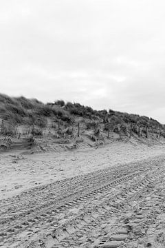 Strand en duinen met bandensporen in zwart-wit van Evelien van Rijn