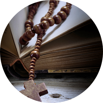 katholieke houten rozenkrans met kruis in een oud boek over rustiek vintage hout, religieus symboolc van Maren Winter