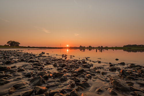Stones at river De Lek during sunset