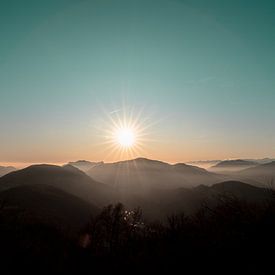 Coucher de soleil en Suisse avec du brouillard, au-dessus des nuages. sur Moments by Kim