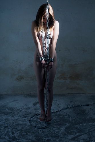 Femme nue menottée avec des chaînes BDSM lourdes sur Photostudioholland