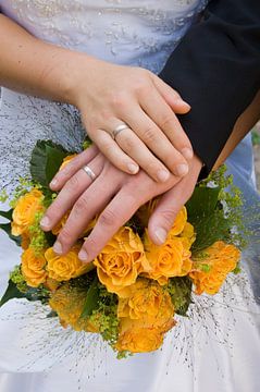 Hände eines Hochzeitspaares auf dem Brautstrauß von Jörg B. Schubert