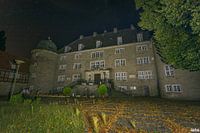Nachtfoto van een verlaten kasteel.