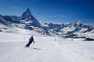 Weiblicher Skifahrer, der auf den Steigungen des Matterhorn Berges Ski fährt von iPics Photography Miniaturansicht