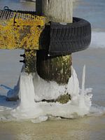 Aanlegpaal in het ijs bij het Lauwersmeer op een winterse dag