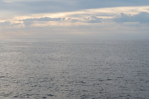 Zilver zeewater en warme grijze wolken