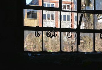 Uitzicht door een vernield raam naar buiten