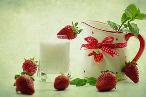 Verträumtes sommerliches Stillleben mit frischen Erdbeeren und frischer Milch im Kännchen