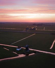 Mühle in einer Polderlandschaft bei einem farbenprächtigen Sonnenuntergang von Ewold Kooistra