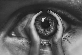 Monochrome Fotografie: Hände, die ein Auge halten - ein Bild der Intimität und Verbindung