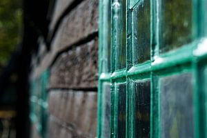 Ancienne grange en bois avec des vitraux et peinte en vert