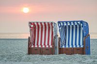 Beach chairs in the sunset by the sea