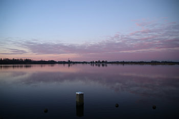 Zonsondergang in paarse gloed reflecteert over de Rottemeren in Zevenhuizen