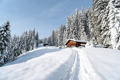 Alpine hut in winter with lots of snow in landscape format