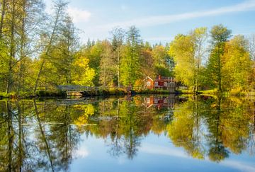 Zweeds huisje weerspiegelt in het meer van Connie de Graaf