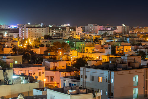 Illuminated houses on the hillside at night, Muscat