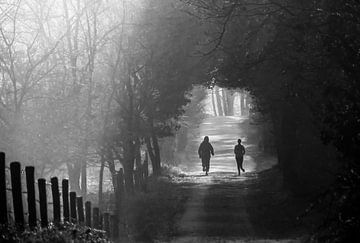 Joggers op een bospad in de mist van Desiree Dorrestijn