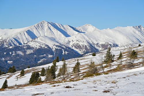 Winterlandschaft mit fernen schneebedeckten Berggipfeln