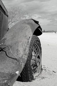Oude verroeste en verlaten oldtimer autowrak in de woestijn. Zwart wit