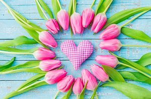 Pink heart and tulip flowers on blue wood background for Mother's day by Alex Winter