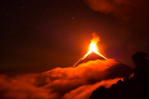 Uitbarsting van de Volcan de Fuego in Guatemala boven de wolken