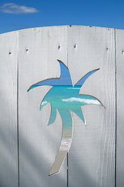 A view of the sea through a palm-shaped gap in the fence by Theodor Decker
