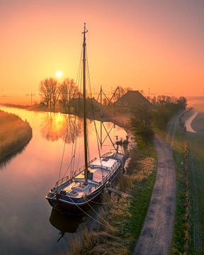 Sunrise in Friesland - Boat along a Misty Canal by Ewold Kooistra