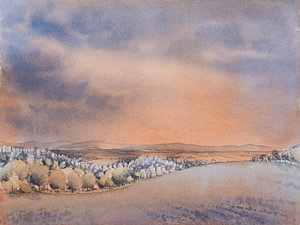 A warm evening sky over rolling hills