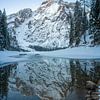 Verschneiter Berggipfel spiegelt sich bei Sonnenaufgang im Pragser Wildsee von t.ART
