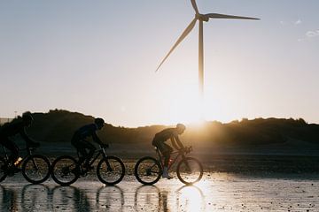 Fietsers op het strand van Wijk aan Zee met tegenlicht van Sander de Vries
