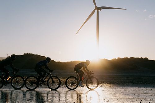 Fietsers op het strand van Wijk aan Zee met tegenlicht