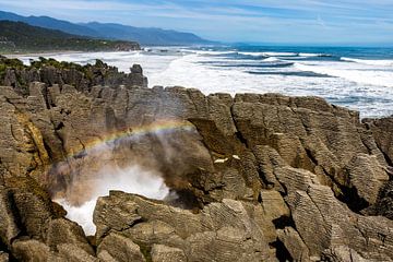 Pancake Rocks blowhole met regenboog, Punakaiki, Nieuw-Zeeland van Paul van Putten