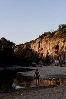 Lever de soleil dans l'Ardèche en France : une fille se promène dans la rivière.